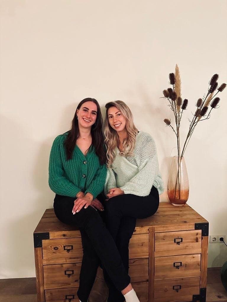 Demi en Lonny zitten samen op een houten kast